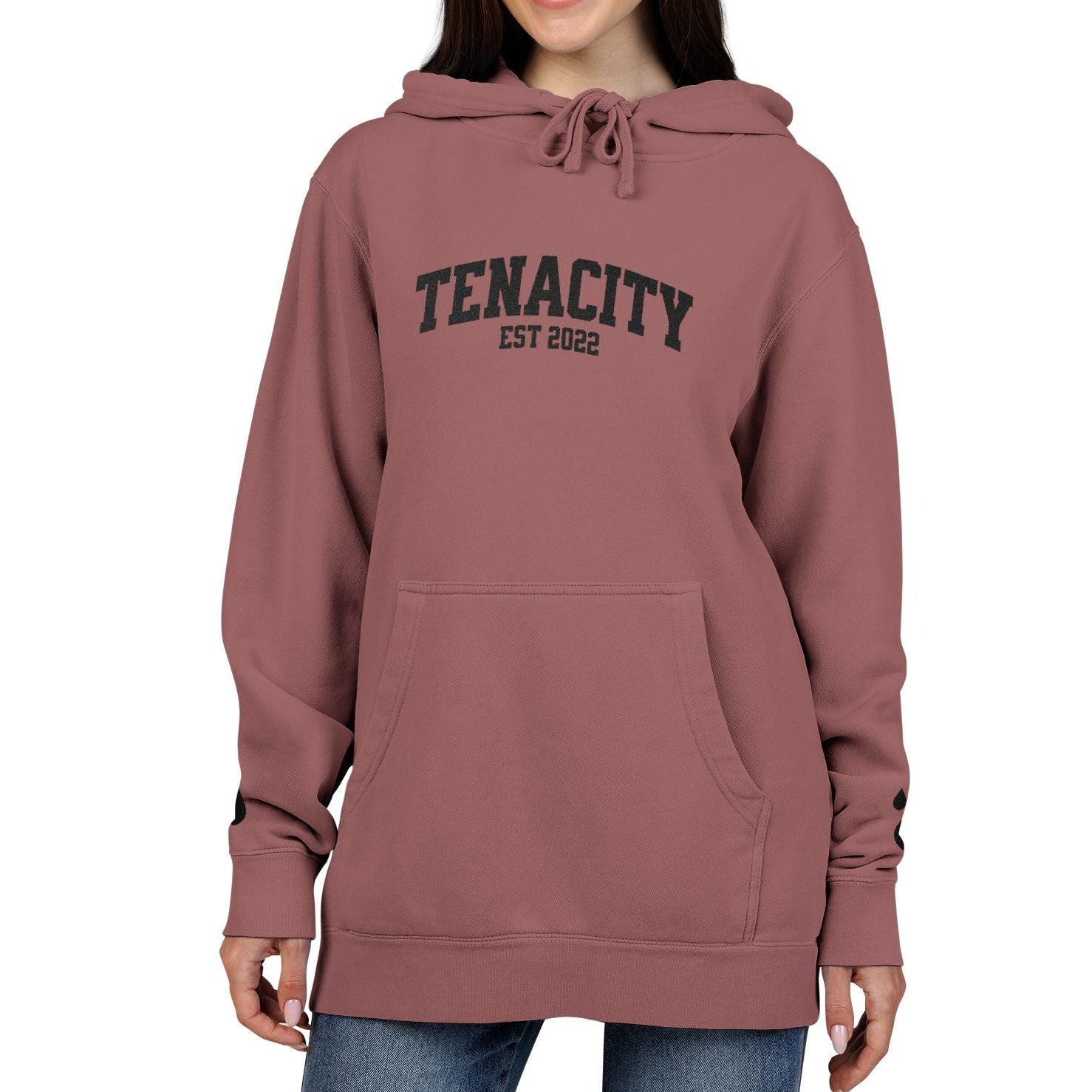 Person wearing a maroon hoodie with 'TENACITY EST 2022' text on a white background