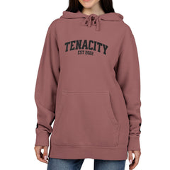 Person wearing a maroon hoodie with 'TENACITY EST 2022' text on a white background